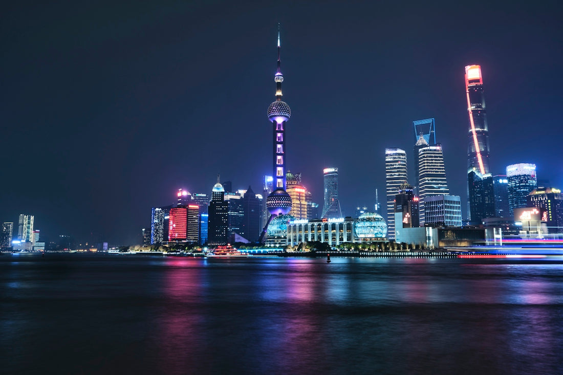 a city skyline at night with lights reflecting off the water